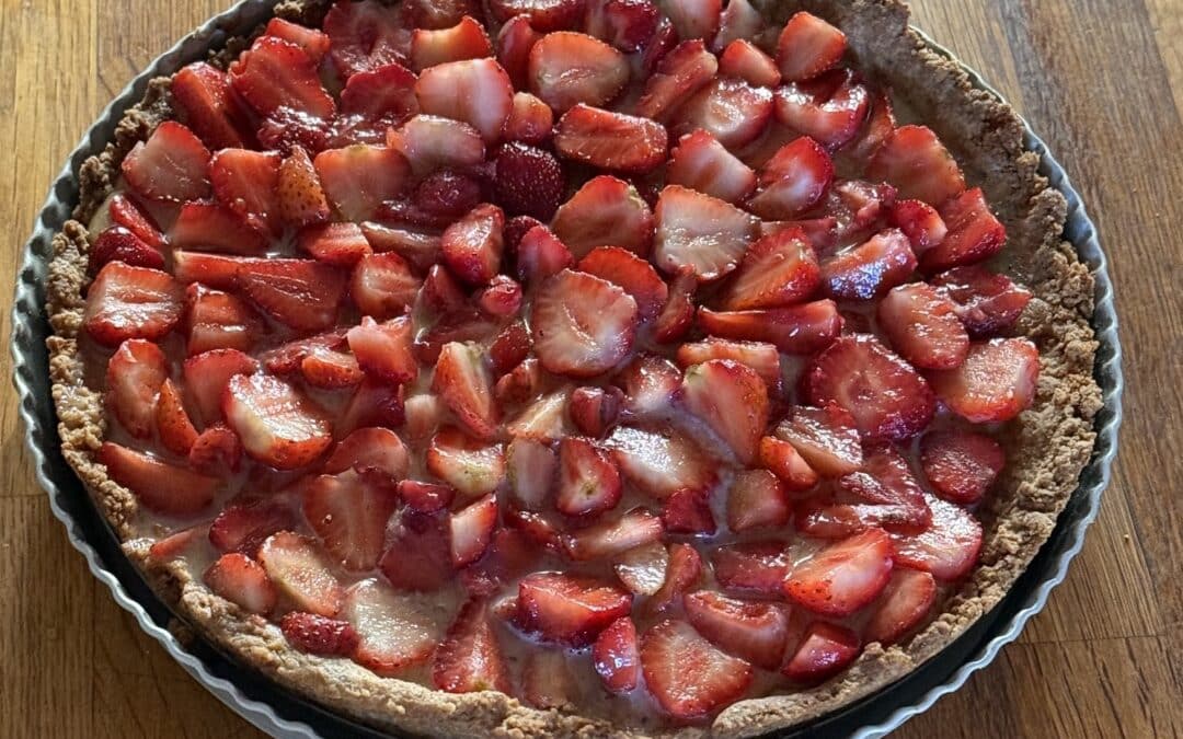 tarte encore dans son moule, pas encore découpé, avec des fraises rouges, provenant de notre potager.
